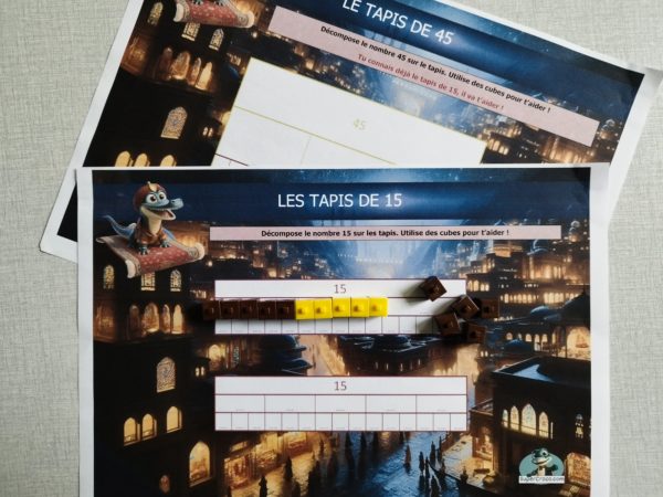 Tapis de décomposition du nombre 15 ou 45, présenté sous forme de lignes horizontales. Chaque ligne correspond à une combinaison de deux quantités dont la somme est le nombre cible. Des cases vides sont prévues pour accueillir des cubes manipulables. Les couleurs permettent de visualiser les liens entre les différentes décompositions et de repérer les régularités.